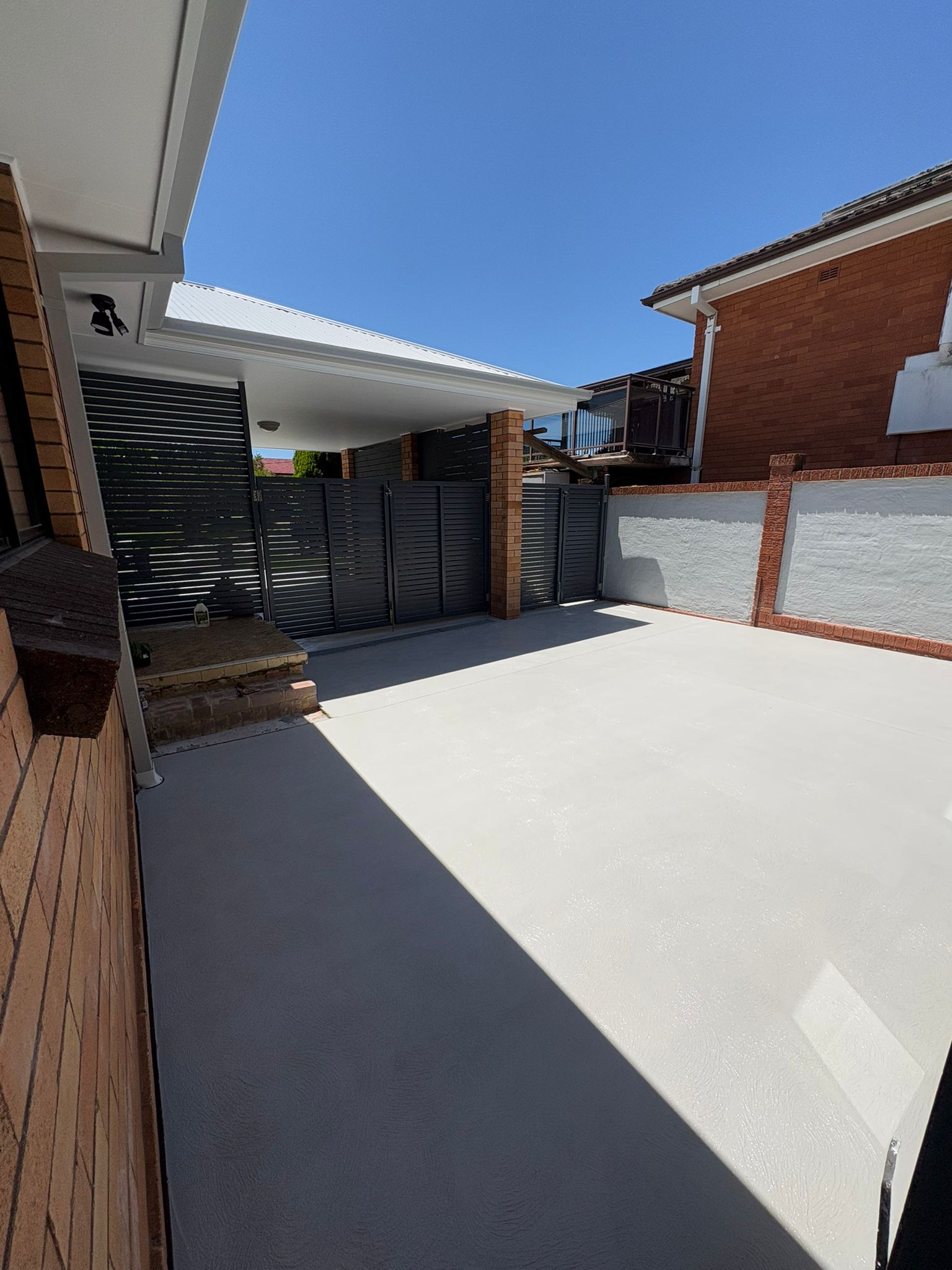 Plain concrete courtyard slab behind a brick home